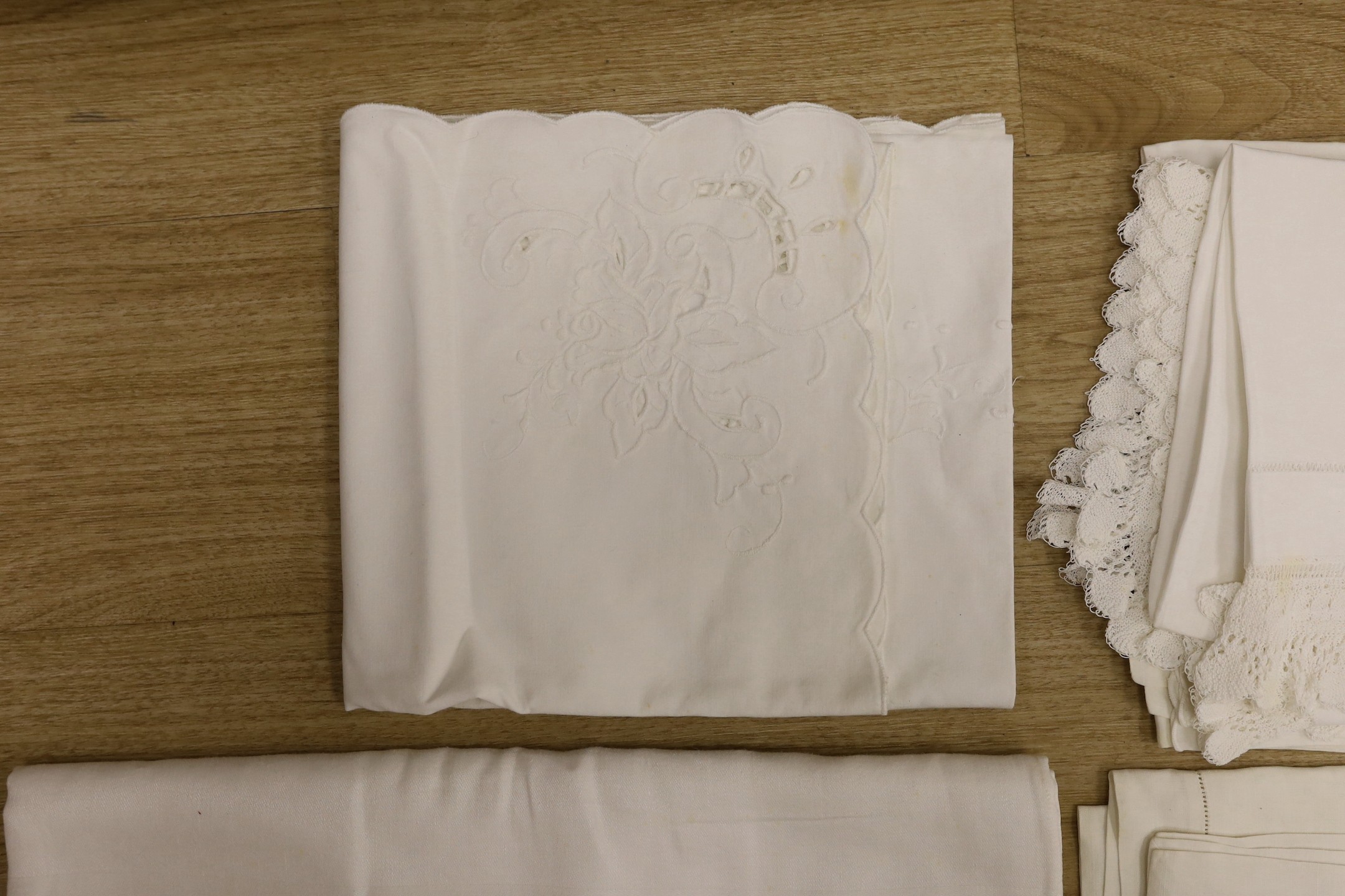 A quantity of lace trimmed and embroidered fabrics including tray cloths and pillow cases
